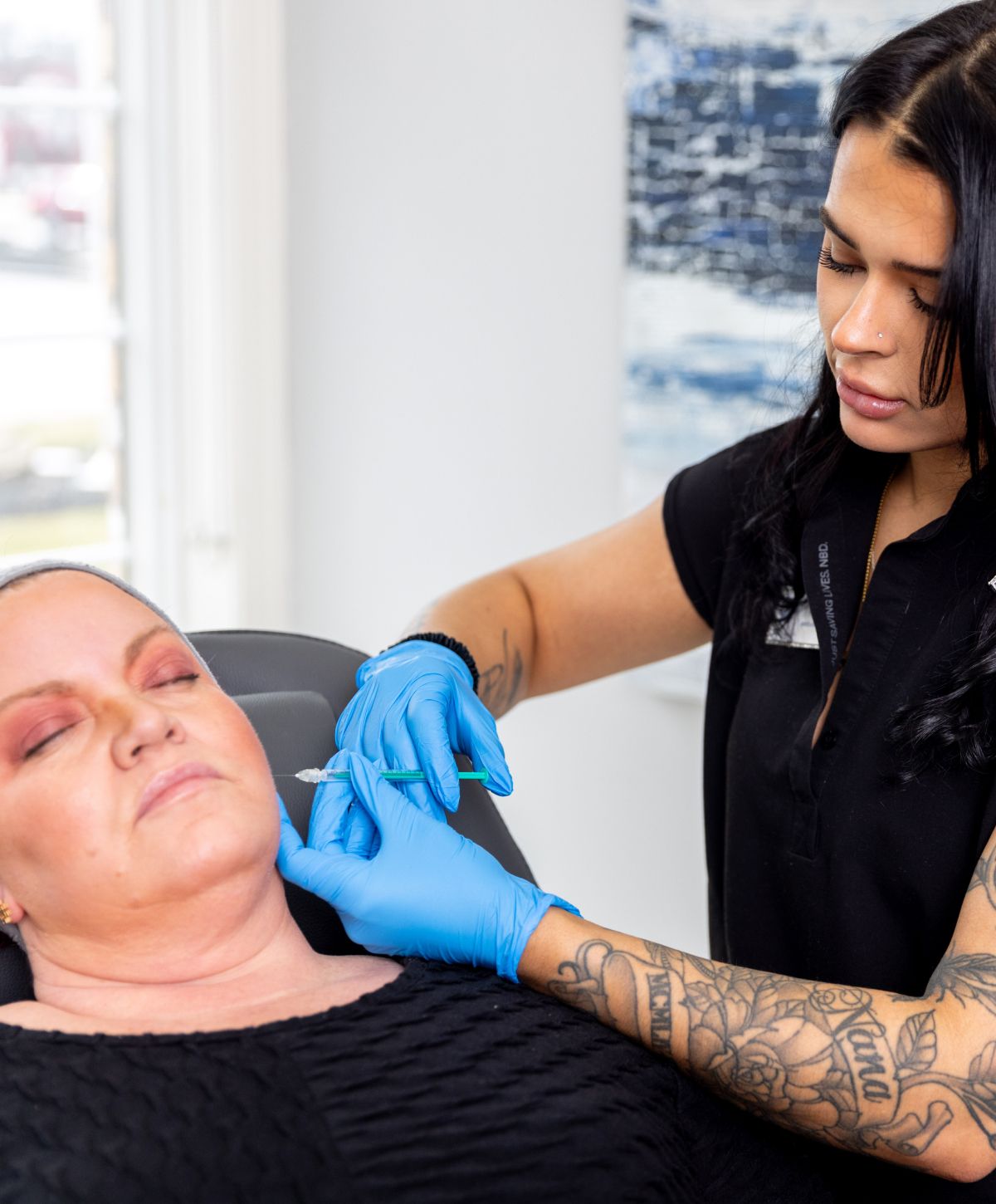 medical aesthetics training student model delivering an injection to a patient model's cheek