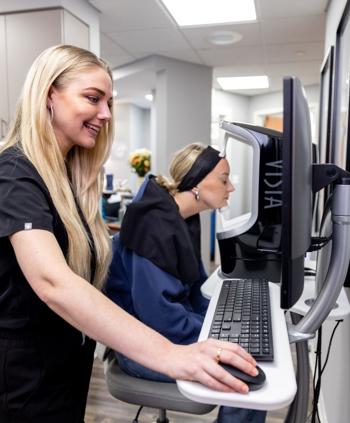 medical aesthetics training student model working on a computer
