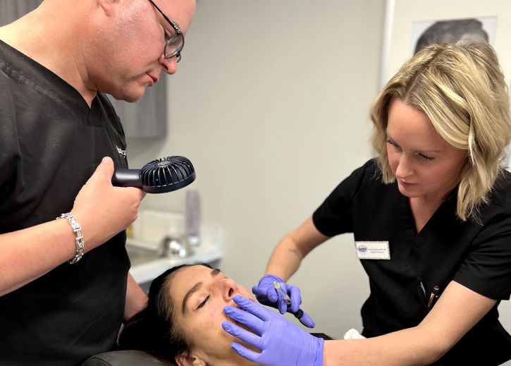 lip filler training student model delivering an injection with the instructor watching