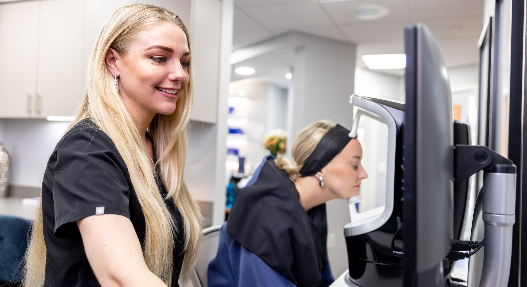 apprenticeship program student model smiling while looking at a computer screen