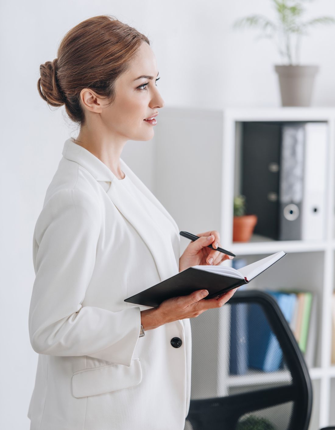 aesthetic training student in a white coat holding a pen and notebook