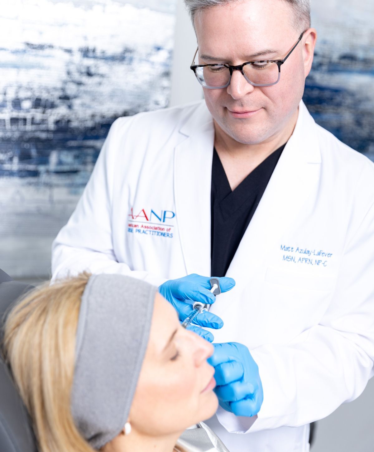 matt azulay-lafever in his lab coat delivering an injectable to a patient model